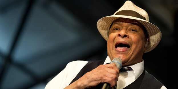 Al Jarreau am Mikrofon, mit weißem Hut und in schwarzer Weste