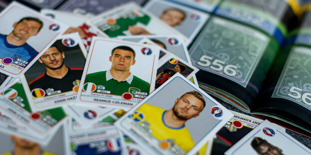 Sammelbilder von Fußballern liegen auf eiem Sammelalbum Sammelbilder von Fußballern liegen auf eiem Sammelalbum