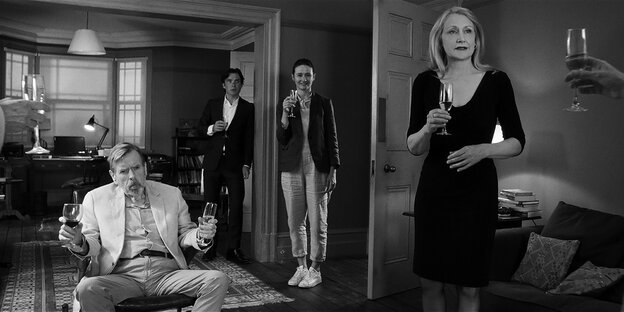 Sechs Darsteller aus Sally Potters Schwarzweißfilm "The Party" stehen steif mit Sektgläsern in der Hand im Raum Sechs Darsteller aus Sally Potters Schwarzweißfilm "The Party" stehen steif mit Sektgläsern in der Hand im Raum