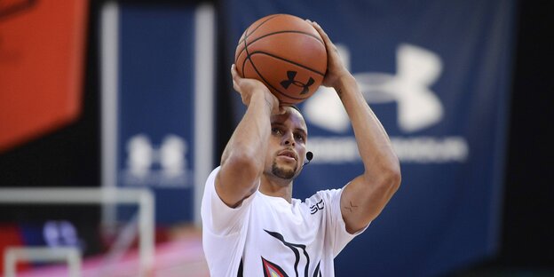 Stephen Curry zielt mit Ball in der Hand auf den Korb Stephen Curry zielt mit Ball in der Hand auf den Korb