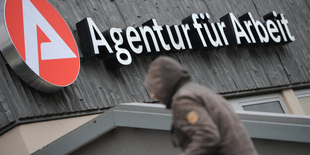 Ein Mensch läuft in ein Gebäude mit der Aufschrift "Agentur für Arbeit" Ein Mensch läuft in ein Gebäude mit der Aufschrift "Agentur für Arbeit"