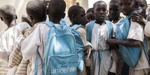 Eine Gruppe afrikanischer Kinder mit blauen UNO-Schulranzen Eine Gruppe afrikanischer Kinder mit blauen UNO-Schulranzen