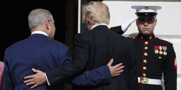 Benjamin Netanjahu und Donald Trump haben die Arme hintern den Rücken des je anderen gelegt. Man sieht sie von hinten Benjamin Netanjahu und Donald Trump haben die Arme hintern den Rücken des je anderen gelegt. Man sieht sie von hinten