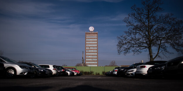 Das VW-Werk unter dunklem Himmel, Autos stehen im Vordergrund