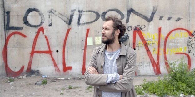 Ein Mann vor einer Grafitti-Wand Ein Mann vor einer Grafitti-Wand