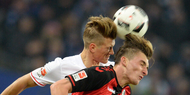 Zwei Männer köpfen einen Fußball Zwei Männer köpfen einen Fußball