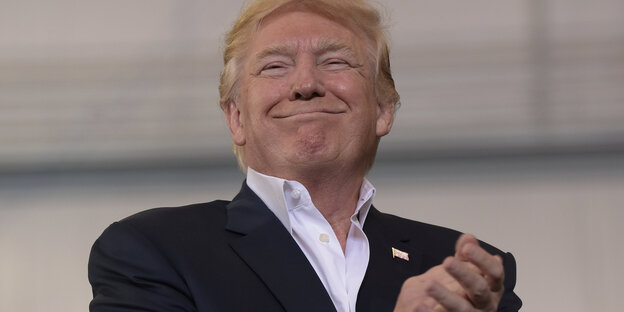 Donald Trump lächelt und hat die Hände ineinander gelegt Donald Trump lächelt und hat die Hände ineinander gelegt