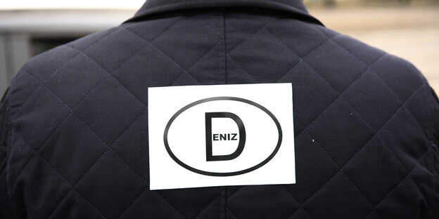 Ein Mann hat einen Aufkleber mit dem Länderkennzeichen «D» und dem Schriftzug «Deniz» steht am 19.02.2017 in Berlin ebi einem Autokorso auf der Straße Ein Mann hat einen Aufkleber mit dem Länderkennzeichen «D» und dem Schriftzug «Deniz» steht am 19.02.2017 in Berlin ebi einem Autokorso auf der Straße