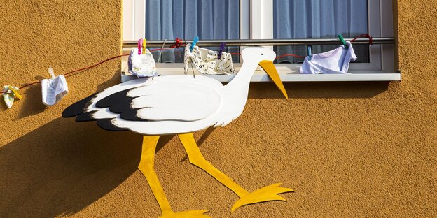Ein Pappstorch klebt an einer Fensterbank Ein Pappstorch klebt an einer Fensterbank
