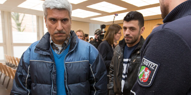 Der klagende Syrer (l) und ein Dolmetscher (M) verlassen am 21.02.2017 den Sitzungssaal des Oberverwaltungsgerichts (OVG) in Münster (Nordrhein-Westfalen). Der klagende Syrer (l) und ein Dolmetscher (M) verlassen am 21.02.2017 den Sitzungssaal des Oberverwaltungsgerichts (OVG) in Münster (Nordrhein-Westfalen).