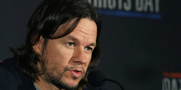 Mark Wahlberg mit kinnlangen, fettigen schwarzen Haaren Mark Wahlberg mit kinnlangen, fettigen schwarzen Haaren