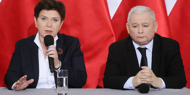 Polens Premierministerin Beata Szydlo mit PiS-Pateichef Jaroslaw Kaczynski an einem Tisch vor rotem Hintergrund Polens Premierministerin Beata Szydlo mit PiS-Pateichef Jaroslaw Kaczynski an einem Tisch vor rotem Hintergrund