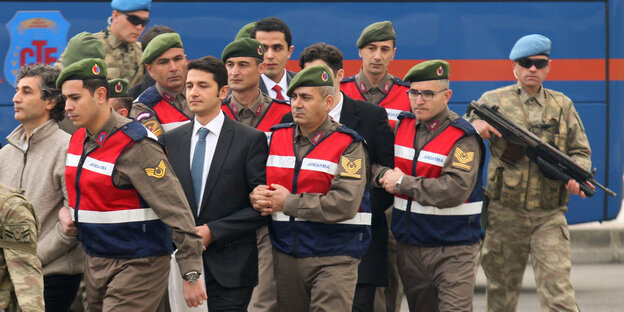 Türkische Soldaten, die wegen eines Mordkomplotts gegen Erdoğan angeklagt sind, werden von Polizisten zum Gericht eskortiert Türkische Soldaten, die wegen eines Mordkomplotts gegen Erdoğan angeklagt sind, werden von Polizisten zum Gericht eskortiert