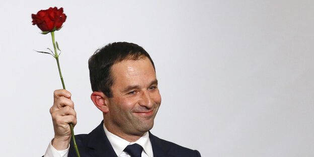 Benoît Hamon hält eine rote Rose