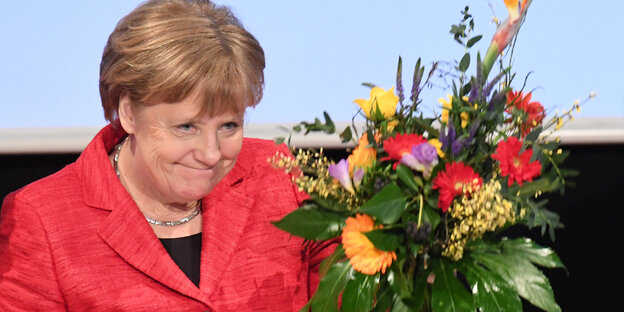 Eine Frau grinst und hält einen Blumenstrauß Eine Frau grinst und hält einen Blumenstrauß