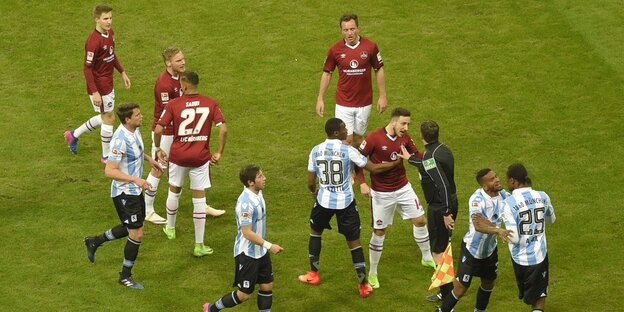Fußballer in roten und weiß-blauen Trikots streiten sich Fußballer in roten und weiß-blauen Trikots streiten sich