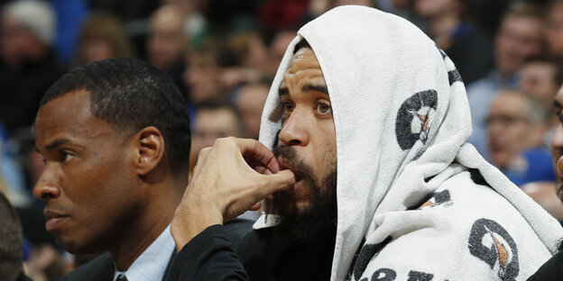 JaVale McGee sitzt am Spielfeldrand und hat ein Handtuch über dem Kopf JaVale McGee sitzt am Spielfeldrand und hat ein Handtuch über dem Kopf