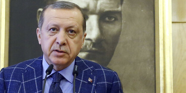 Ein Mann spricht in ein Mikrofon. Hinter ihm hängt ein Portrait des türkischen Staatsgründers Atatürk Ein Mann spricht in ein Mikrofon. Hinter ihm hängt ein Portrait des türkischen Staatsgründers Atatürk