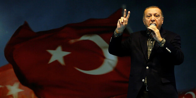 Erdogan steht vor einer türkischen Flagge Erdogan steht vor einer türkischen Flagge