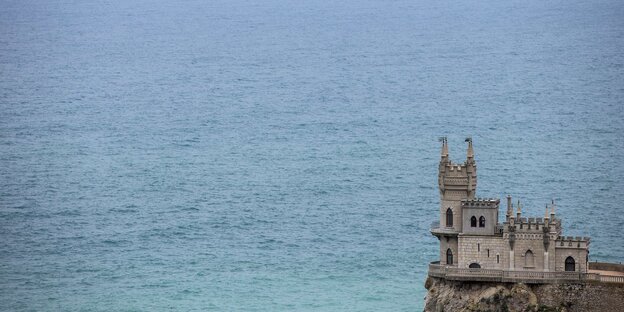 Ein Fels, auf dem ein Haus steht, ragt über das Meer Ein Fels, auf dem ein Haus steht, ragt über das Meer