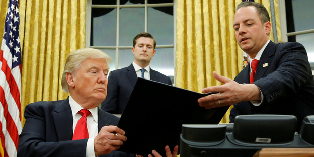 US-Präsident Trump gibt einem Mann eine Akte US-Präsident Trump gibt einem Mann eine Akte