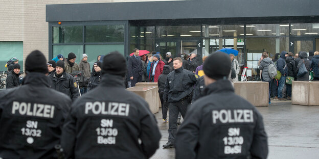 Polizisten, Besucher und Demonstranten vor einem gerichtsgebäude Polizisten, Besucher und Demonstranten vor einem gerichtsgebäude