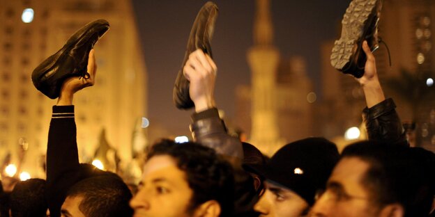 Demonstranten halten am Tahrirplatz aus Protest gegen die Regierung Schuhe in die Luft Demonstranten halten am Tahrirplatz aus Protest gegen die Regierung Schuhe in die Luft