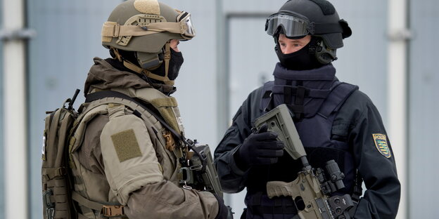 ein Bundeswehrsoldat und ein Polizist in schwerer Ausrüstung ein Bundeswehrsoldat und ein Polizist in schwerer Ausrüstung