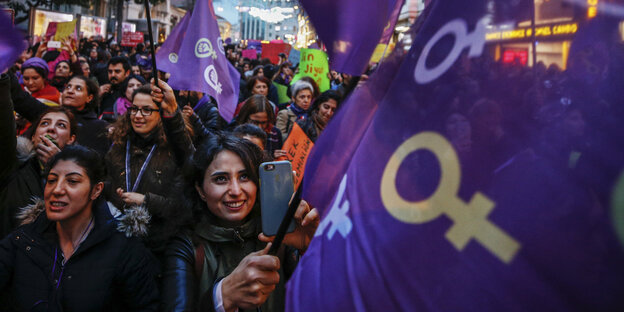 Lachende Frauen mit lialafarbenen Fahnen ziehen zum Frauentag durch Istanbul Lachende Frauen mit lialafarbenen Fahnen ziehen zum Frauentag durch Istanbul