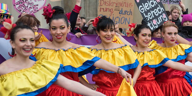 Frauen in bunten Kleidern stehen am 8. März vor dem Brandenburger Tor in Berlin Frauen in bunten Kleidern stehen am 8. März vor dem Brandenburger Tor in Berlin