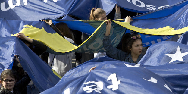 Menschen halten blaue Banner in die Luft Menschen halten blaue Banner in die Luft