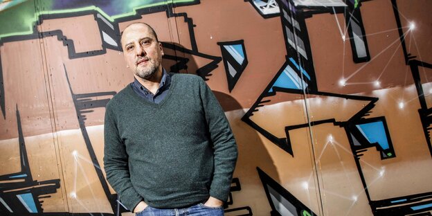 Porträt von Ahmet Şık vor Wand mit Graffiti