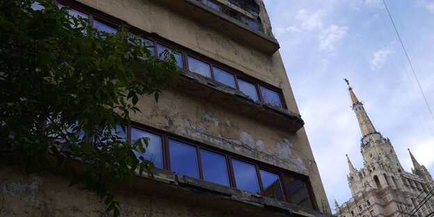 Eine zerfallende Gebäudefassade im Vordergrund und ein glänzender Stalin-Bau im Hintergrund Eine zerfallende Gebäudefassade im Vordergrund und ein glänzender Stalin-Bau im Hintergrund