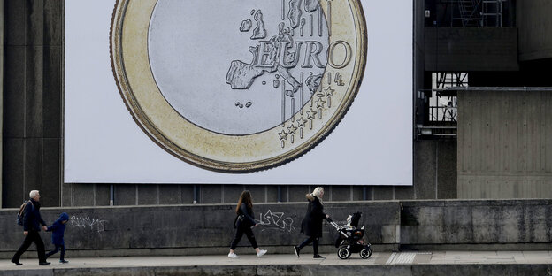 Menschen laufen auf einem leicht ansteigendem Weg unter einem großen Euro-Plakat Menschen laufen auf einem leicht ansteigendem Weg unter einem großen Euro-Plakat