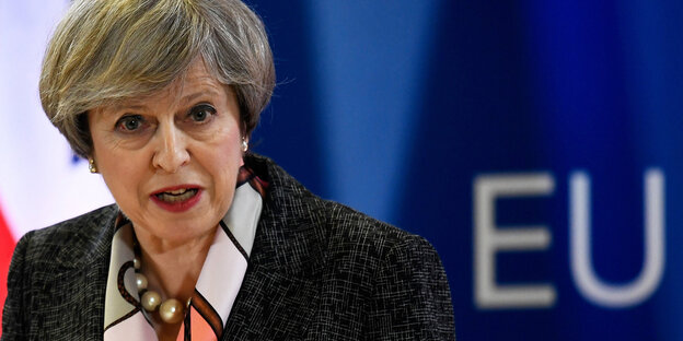 Theresa May redet vor einer Fahne der EU Theresa May redet vor einer Fahne der EU