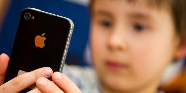 Ein kleines Kind schaut ein iPhone an. Ein kleines Kind schaut ein iPhone an.