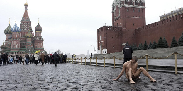 Ein nackter Mann sitzt auf dem Roten Platz in Moskau Ein nackter Mann sitzt auf dem Roten Platz in Moskau