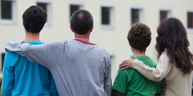 Rückenansicht von vier Familienmitgliedern Rückenansicht von vier Familienmitgliedern