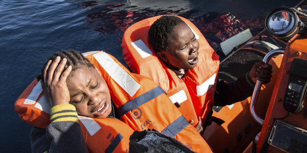 Zwei weinende junge Flüchtlinge in Rettungswesten Zwei weinende junge Flüchtlinge in Rettungswesten