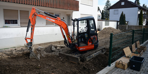 Ein Bagger wühlt einen Garten um