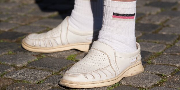 Sandalen mit Tennissocken und verwaschener Deutschlandflagge