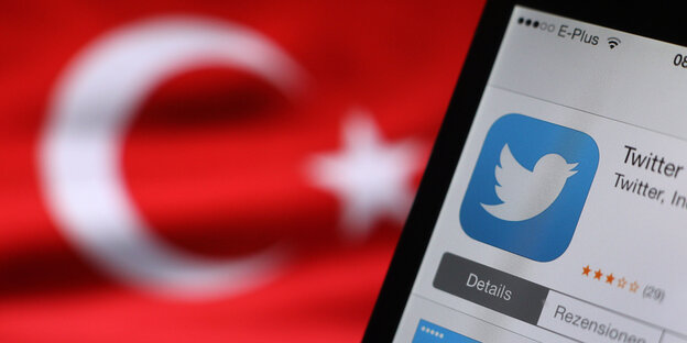 Im Hintergrund eine türkische Nationalflagge, rechts im Vordergrund ein Smartphone, auf dem im App-Store Twitter heruntergeladen wird Im Hintergrund eine türkische Nationalflagge, rechts im Vordergrund ein Smartphone, auf dem im App-Store Twitter heruntergeladen wird