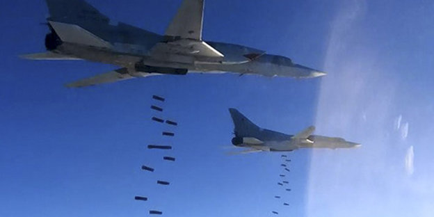 Zwei Kampfjets werfen vor blauem Himmel Bomben ab