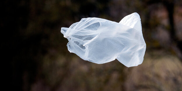 eine weiße Plastiktüte bauscht sich und fliegt im Wind davon eine weiße Plastiktüte bauscht sich und fliegt im Wind davon