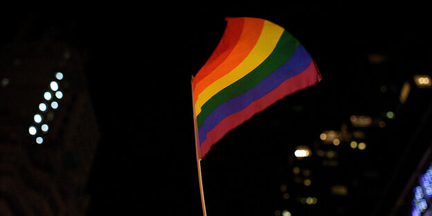 Eine Regenbogenflagge in der Dunkelheit Eine Regenbogenflagge in der Dunkelheit