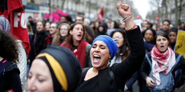 Frauen rufen, eine hebt ihre geballte Faust in die Höhe Frauen rufen, eine hebt ihre geballte Faust in die Höhe