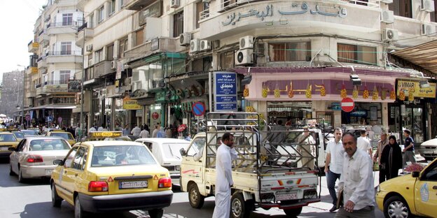 Straßenszene in Damaskus aus dem Jahr 2008: Taxis und Passanten vor altem Gebäude Straßenszene in Damaskus aus dem Jahr 2008: Taxis und Passanten vor altem Gebäude