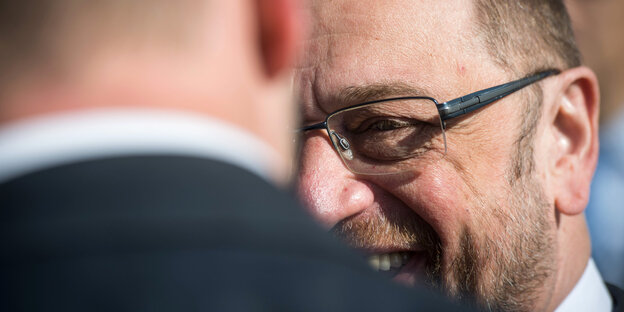 Martin Schulz strahlt jemanden an, sein Gesicht ist jedoch halb hinter dieser Person verborgen Martin Schulz strahlt jemanden an, sein Gesicht ist jedoch halb hinter dieser Person verborgen