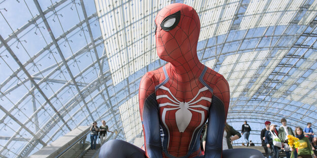 Eine als Spiderman verkleidete Person hockt in Hab-Acht-Stellung auf der Leipziger Buchmesse