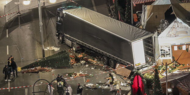 Ein Sattelschlepper steht zwischen den Trümmern von Weihnachtsmarktbuden